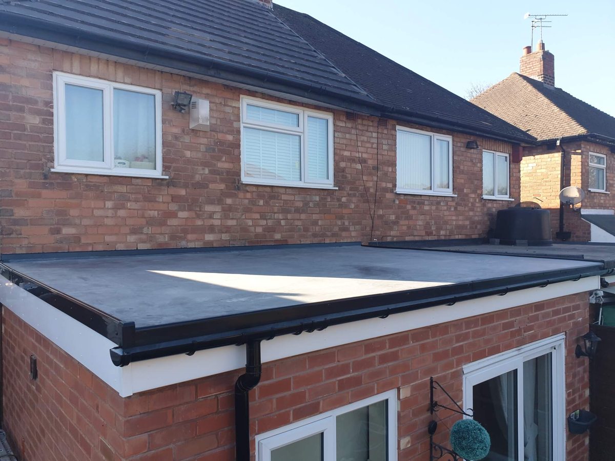New dark flat roof with black guttering and white fascia boards installed by J5 Roofing